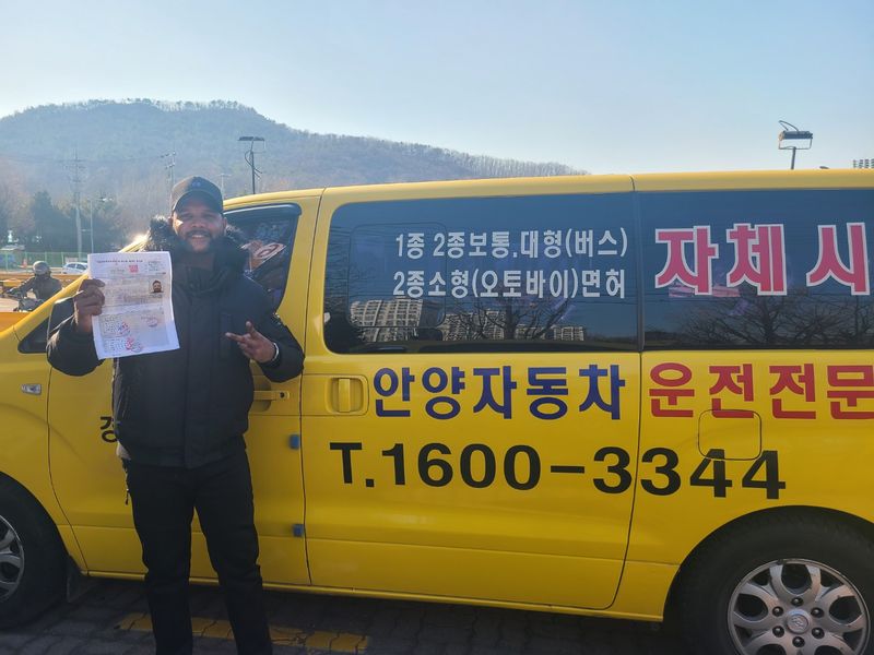 International student celebrating a road driving test pass at Anyang Driving School