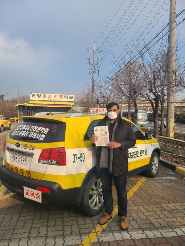 International student celebrating a road driving test pass at Anyang Driving School