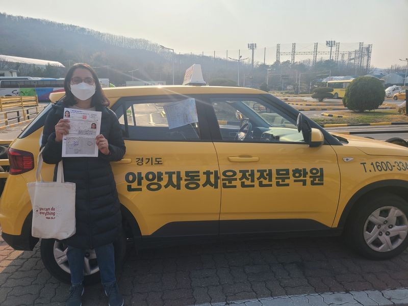 Foreign student holding a newly issued Korean driver's licence at Anyang Driving School