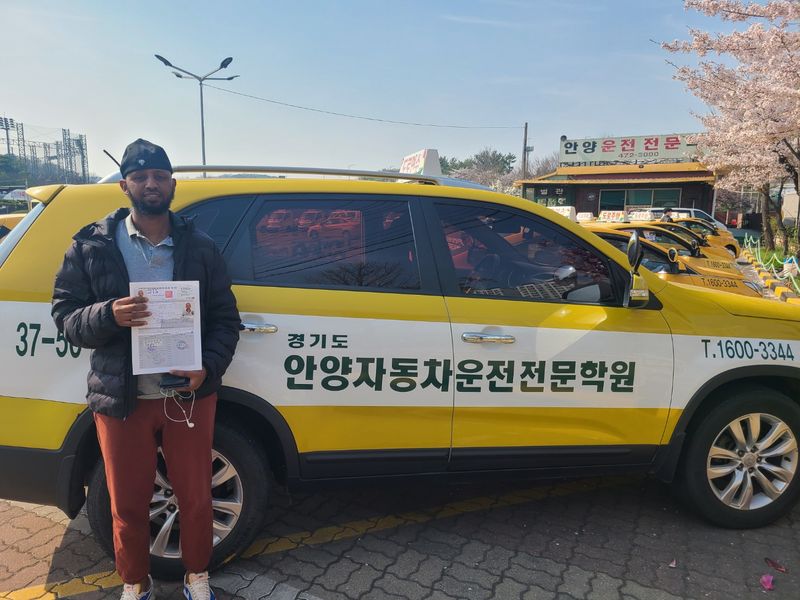 International student celebrating a road driving test pass at Anyang Driving School