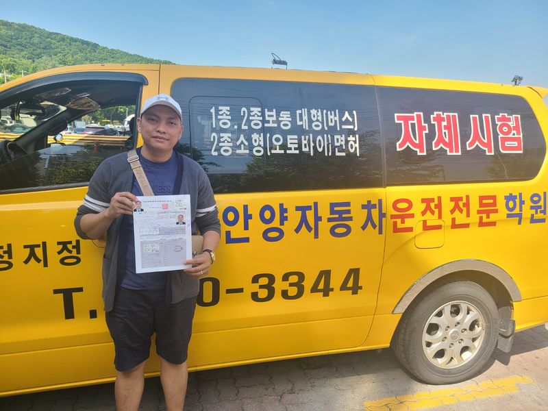 International student celebrating a road driving test pass at Anyang Driving School