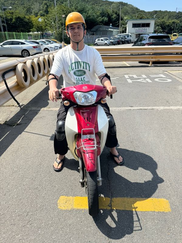 International student celebrating a road driving test pass at Anyang Driving School