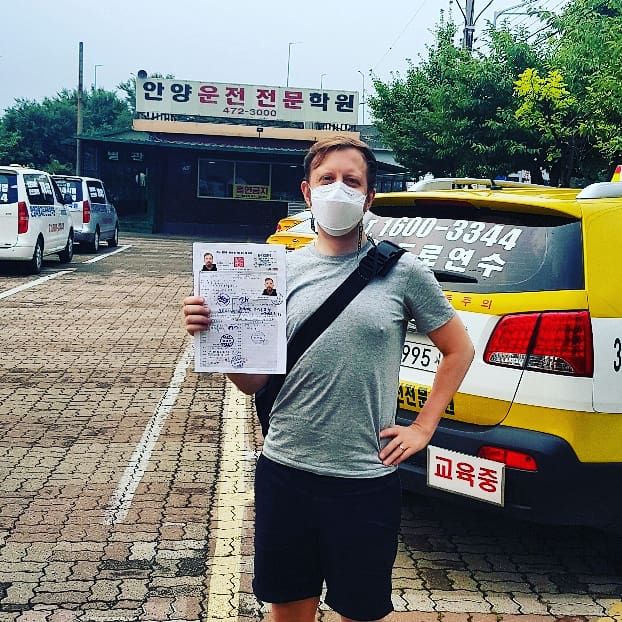 International student celebrating a road driving test pass at Anyang Driving School