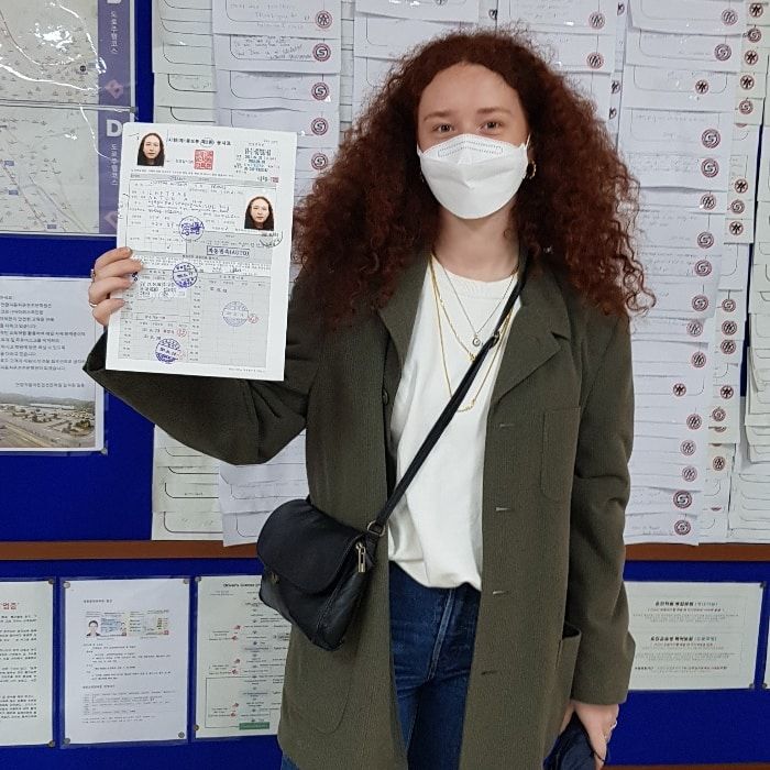 Foreign student holding a newly issued Korean driver's licence at Anyang Driving School