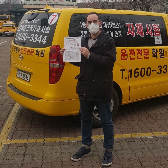 International student celebrating a road driving test pass at Anyang Driving School