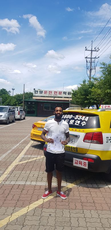 International student celebrating a road driving test pass at Anyang Driving School