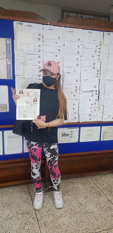 International student celebrating a road driving test pass at Anyang Driving School